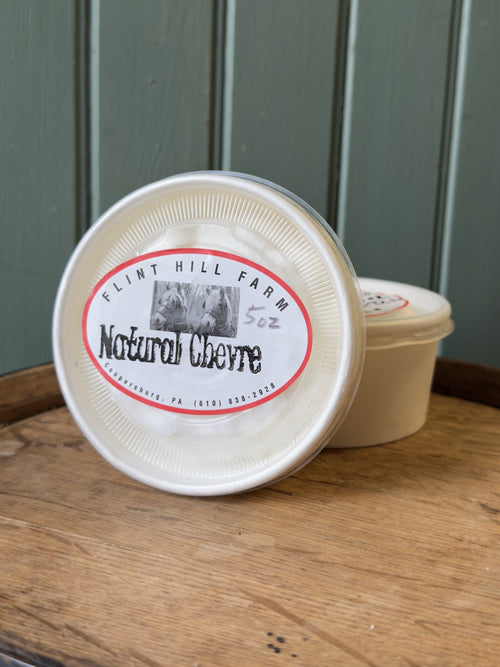 Cup of Flint Hill Farm natural chèvre on a wooden barrel