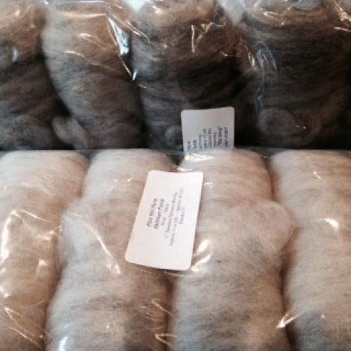 Mantas de lana cardada empaquetadas, en gris pardo y crema, selladas en bolsas transparentes con etiquetas colgantes impresas de Flint Hill Farm