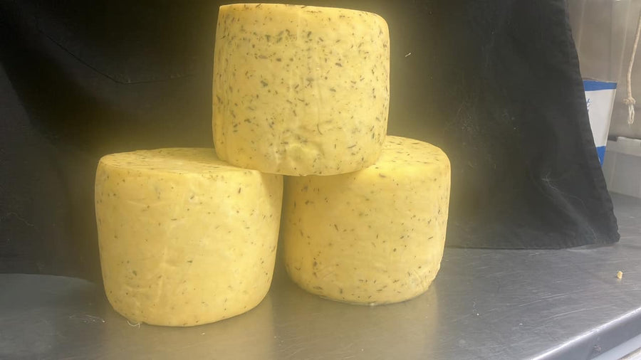 Cheese wheels stacked in the cheese room